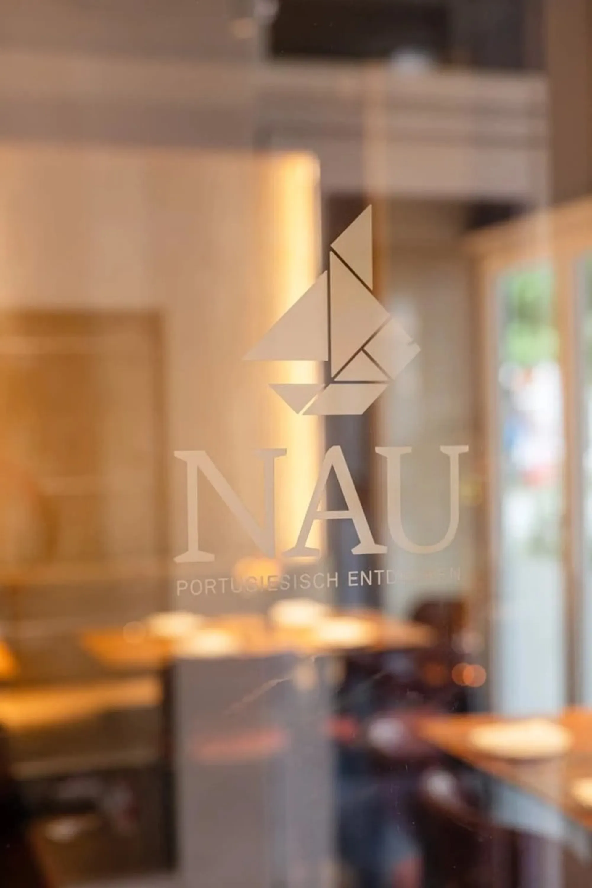 Das NAU-Logo, geätzt in die Glastür des Restaurants