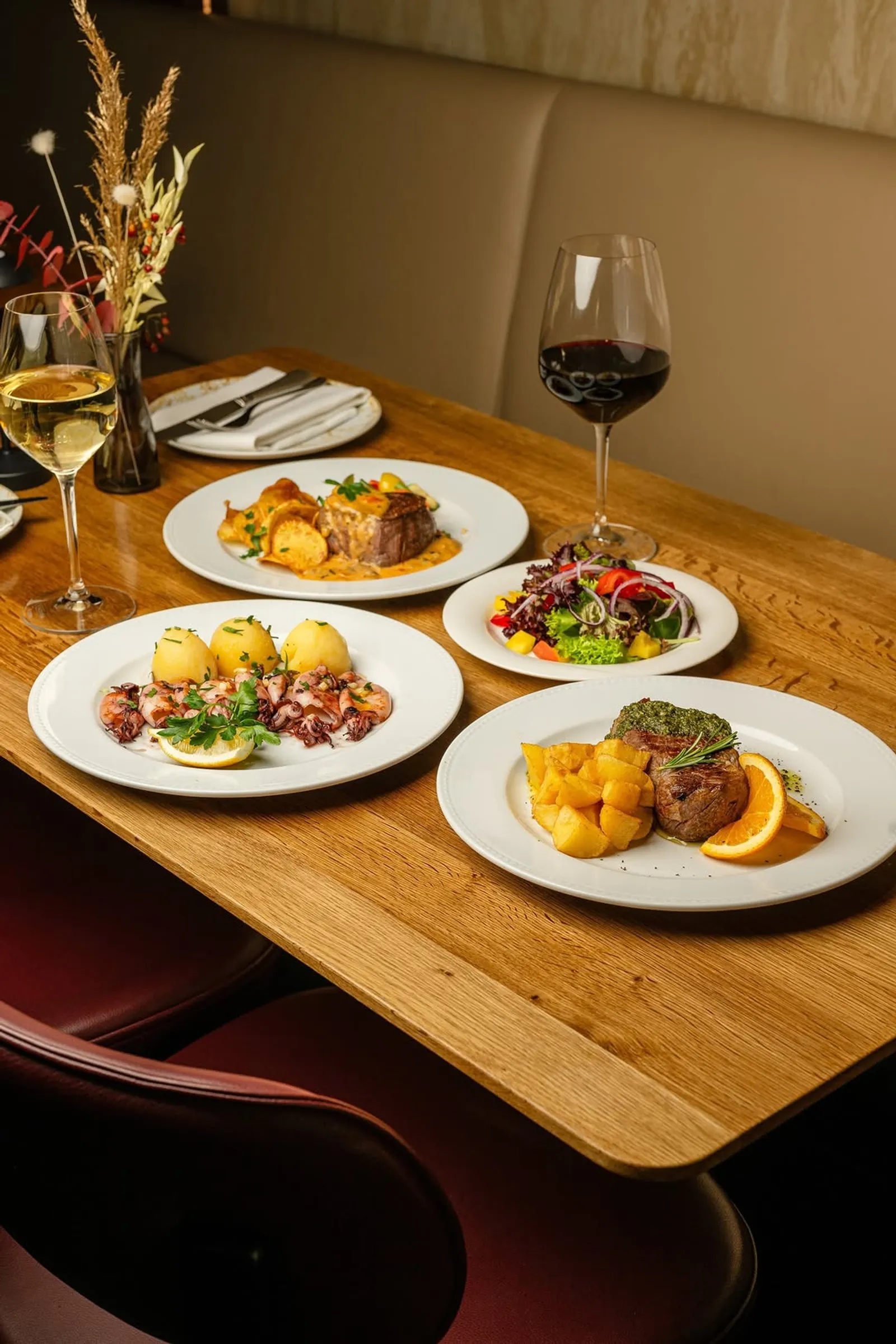 Gedeckter Tisch im NAU mit mehreren Gerichten und Wein